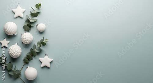 Elegant Christmas ornaments and eucalyptus leaves on a pastel blue background