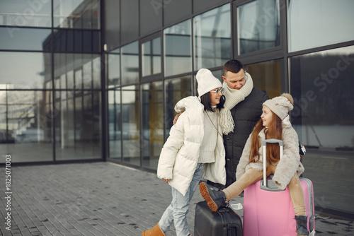 Family sitting outdoors on a luggage and waiting for travel