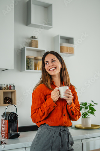 Fotografie Woman enjoying morning coffee ritual in kitchen
