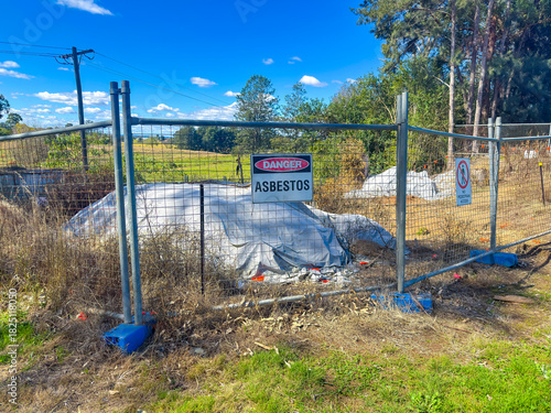 Photograph of a Danger Warning Sign on a fence barricade notifying people of Asbestos at a small construction site in regional New South Wales, Australia. 