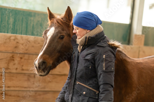 Obraz na plátně Woman training a chestnut horse in a round pen during groundwork communication s