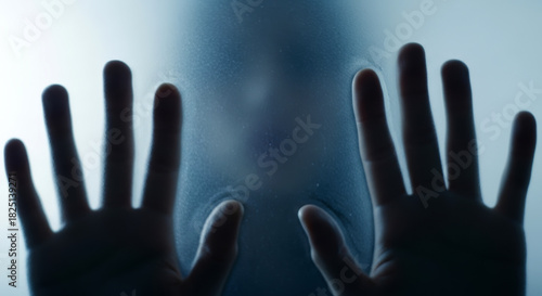 Hand pressed against frosted glass