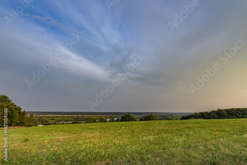 Large, open field with a cloudy sky in the background