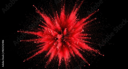 Vibrant red powder explosion captured against a stark black background, creating a dynamic and energetic burst effect resembling a starburst or abstract paint splash