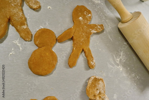 A gingerbread man with a monk lies on a gray background of the tabletop