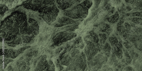 Abstract close-up of turbulent green water surface with foamy bubbles and swirling patterns, creating a dynamic and organic texture for natural or environmental themes