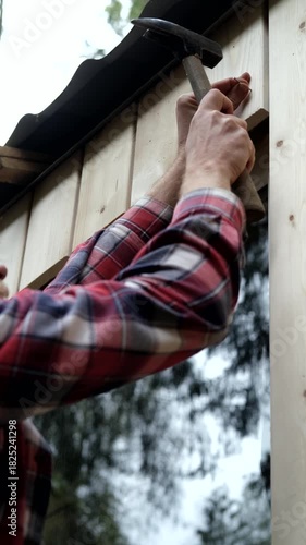 Handyman installing wooden trim with hammer, camera zooms in on action