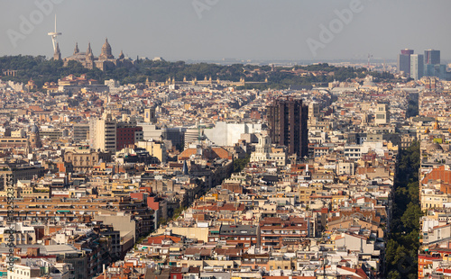 Photography modern view of Barcelona's dense urban landscape with the green Montjuic Hill, t