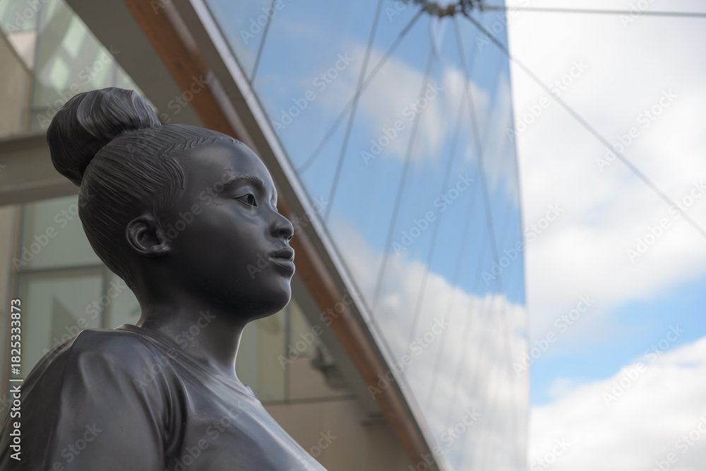 Fototapeta premium bronze sculpture of a Black woman outside the Art Gallery of Ontario (AGO), called Moments Contained, created by the British sculptor Thomas J Price, installed in 2022, Toronto