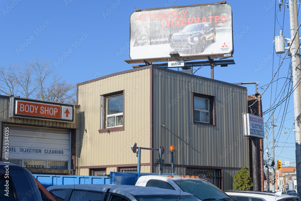 Fototapeta premium rooftop billboard and exterior building and signs at C Auto Collision Center, an auto body shop, located at 1140 Weston Rd, Toronto