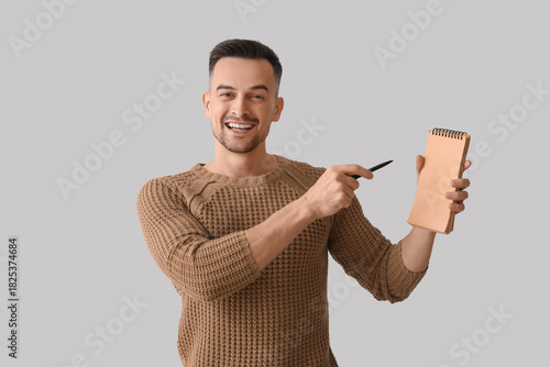 Happy young man with notebo...