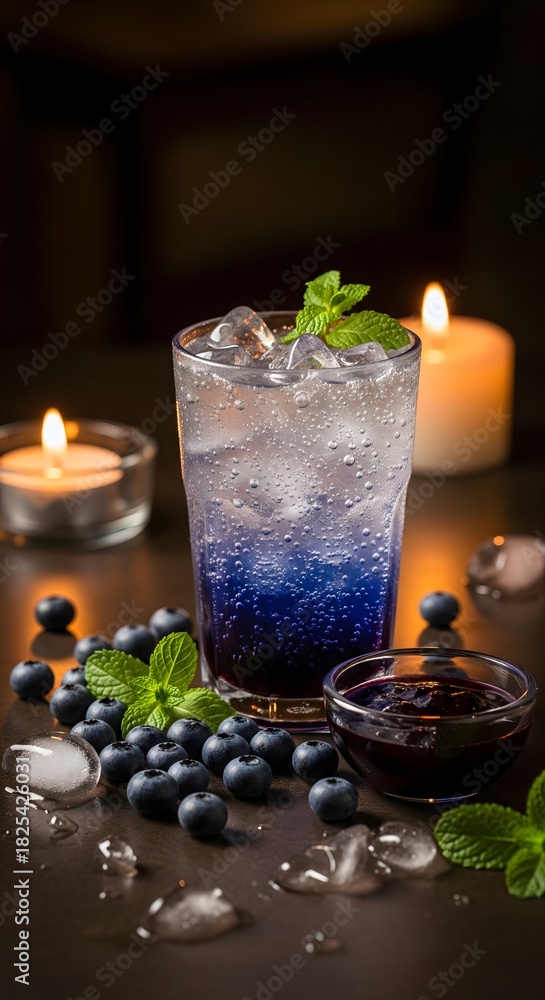Obraz premium Refreshing Blueberry Mint Drink with Ice and Candlelight
