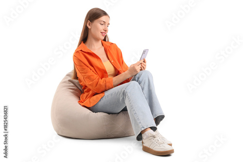 Schilderij op canvas Beautiful young woman with modern mobile phone sitting on beanbag chair against