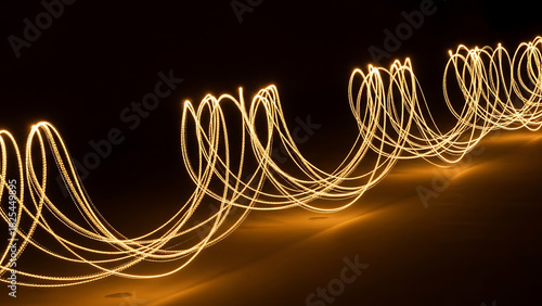 Stunning golden light trails create dynamic, flowing patterns for modern designs and backgrounds