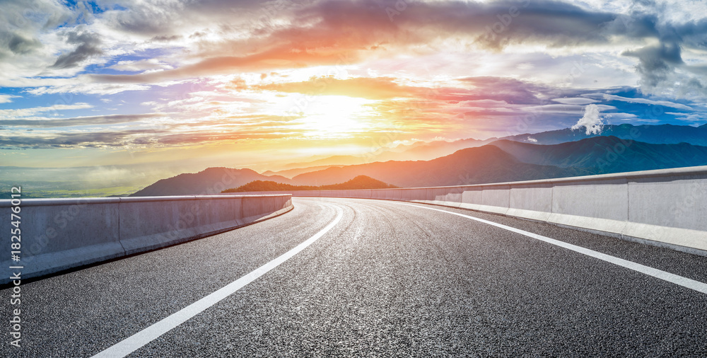Fototapeta premium Empty asphalt road and beautiful mountain with dramatic clouds natural landscape at sunrise