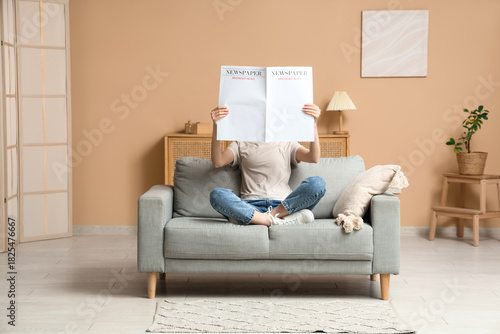 Young woman reading blank n...