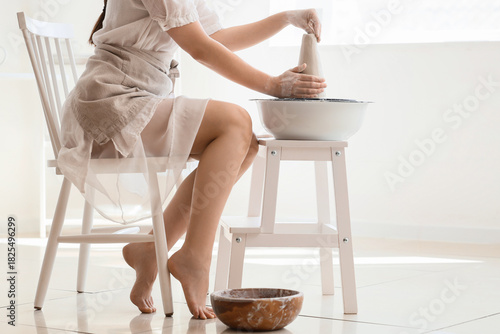 Young female potter shaping...