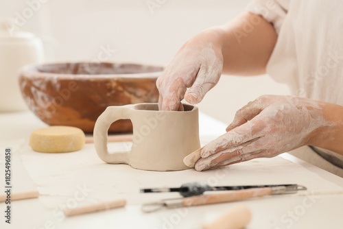 Young female potter shaping...