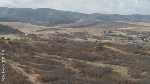 Aerial of Sedalia Colorado homes in dry mountain hillsides in fall on cloudy day