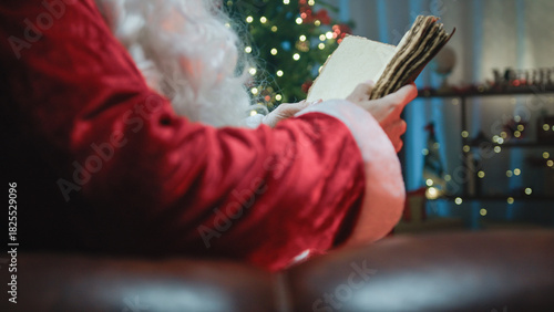 Santa Claus reading an old book on the sofa