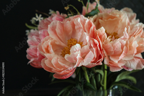 Fototapeta Naklejka Na Ścianę i Meble -  Pink and peach peonies against black background