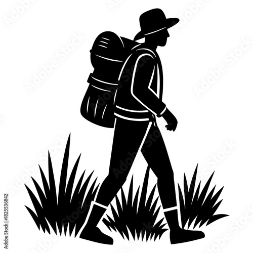 Silhouette of a hiker with a backpack walking through grass