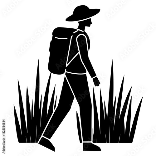 Silhouette of a person with a backpack walking through tall grass wearing a hat