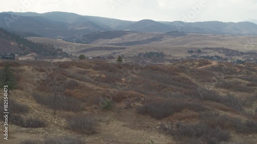 Aerial of dry grassy hillsides in Sedalia Colorado in fall on cloudy day