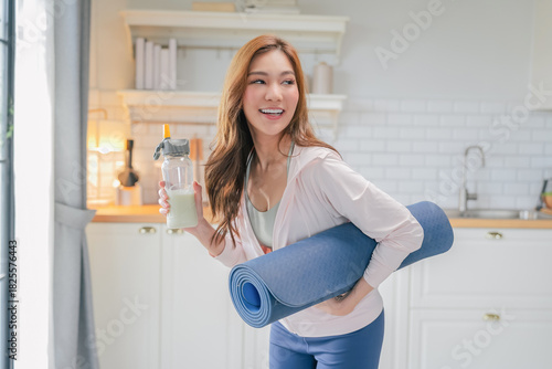Obraz na plátne radiant fitness woman laughs joyfully in the sunshine while holding her water bo