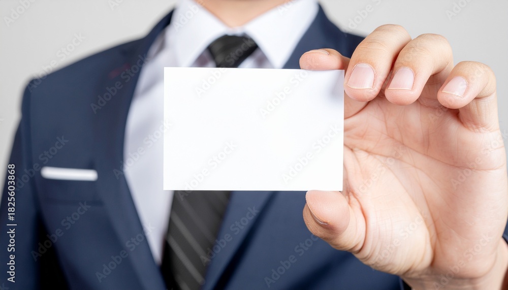 Obraz premium Business Card Presentation: A professional, formally dressed individual presents a blank business card, symbolizing networking, corporate identity, and potential.