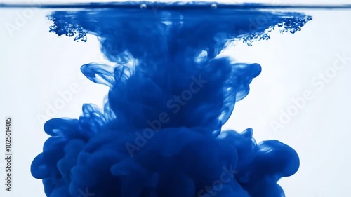 Captivating Underwater Ink Cloud A Mesmerizing Display of Blue Dye Dissolving in Clear Water Creating Abstract Shapes and Patterns in a Serene Aquatic Environment Perfect for Backgrounds and Visual E.