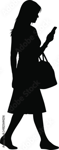Silhouette of a stylish woman walking while checking her phone
