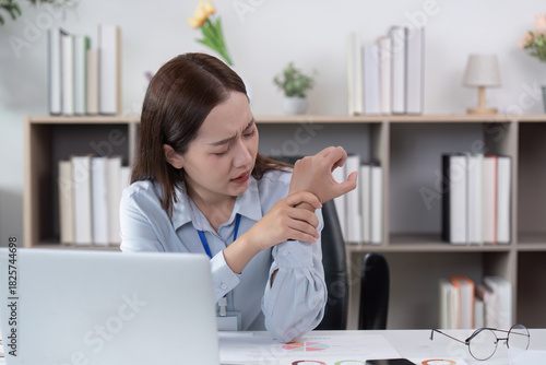 Travel Planning. Woman experiencing wrist pain while working.