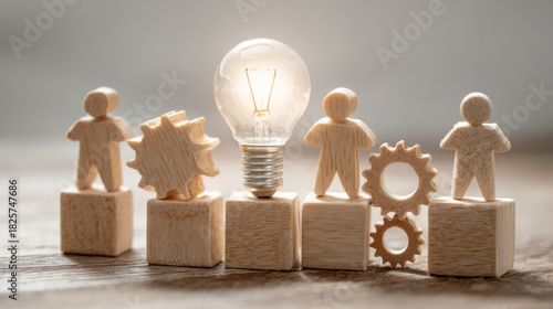 Wooden figures stand on blocks next to a glowing light bulb and gear shapes representing ideas and teamwork in design and engineering. The setting is bright and inviting.
