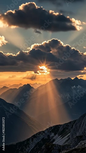 Stunning Mountain Sunset with Golden Sun Rays and Dramatic Clouds.