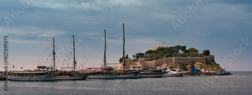 Bild auf Leinwand Guvercinada Castle, Pigeon Island, and traditional boats docked in Kusadasi, Turkey