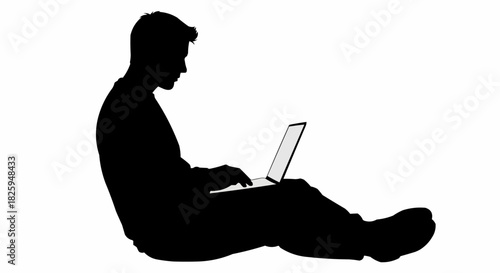 Silhouette of a man sitting on the floor using a laptop computer.