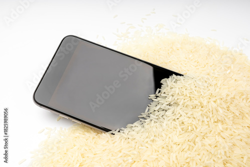 A wet smartphone is dried in rice on white background