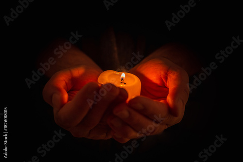 Photography Hand holding burning candle in dark background