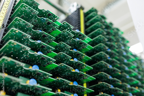 Stacks of assembled circuit boards in rack at modern electronics factory