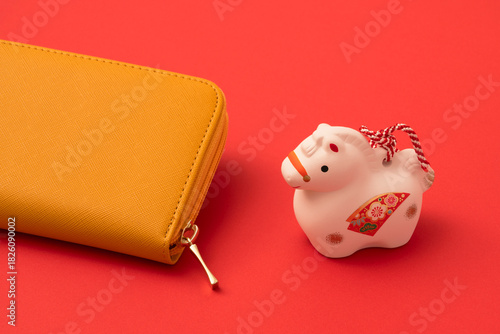 Fotografie A yellow wallet and a Japanese ornament of the zodiac Horse