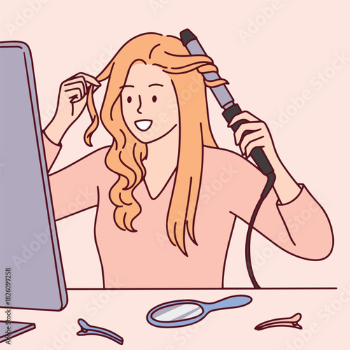 Beautiful blonde woman styles her hair using a curling iron while looking in the mirror. Girl preparing for a holiday event or romantic date making a hairstyle at home.