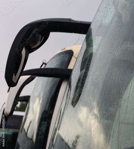 A line of buses in a bus park.