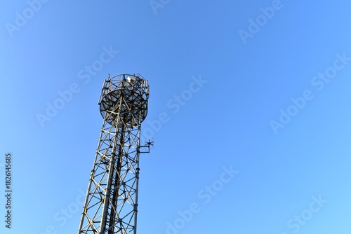 Looking up at a mobile phone tower on a sunny day.