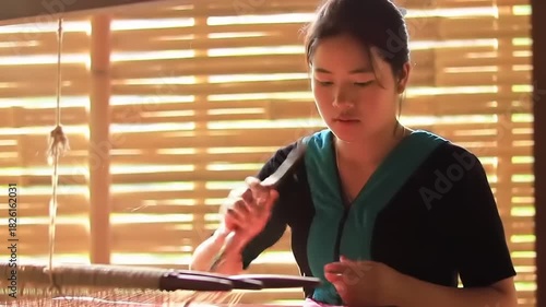 Young woman weaving traditional textile.