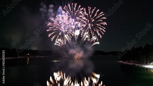 Spectacular Fireworks Display Over Calm Water at Night.