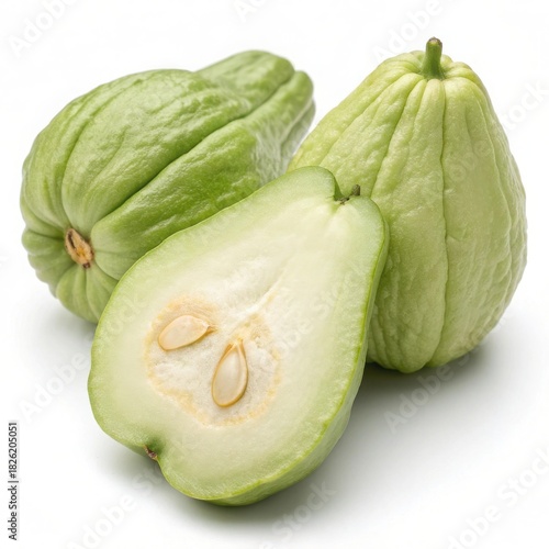 Three fresh light green chayote squashes one cut open revealing seeds healthy produce