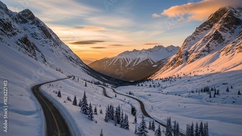 Winding Road Through Snow-Covered Mountains at Sunset.