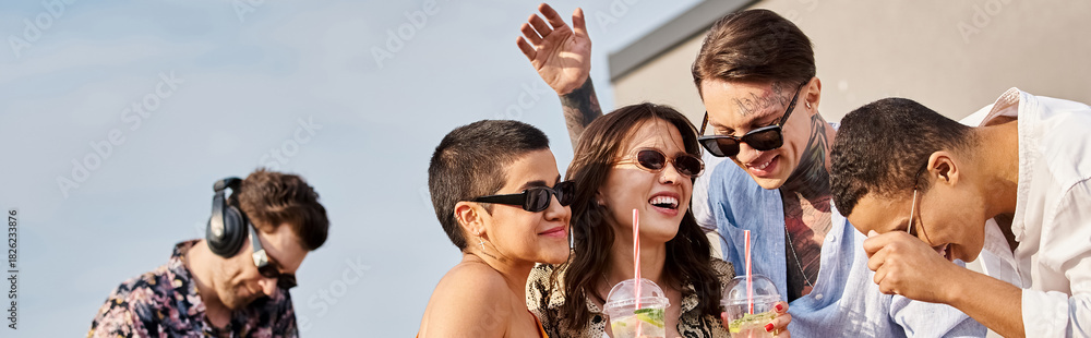 Obraz premium Young friends enjoying a vibrant party on the rooftop as the sun sets
