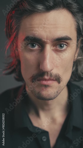 Comical Empty Gaze of a Young Attractive Man with Mustache and Long Hair, Caucasian European, Slavic Appearance, Showcasing Various Facial Emotions in Dramatic Lighting